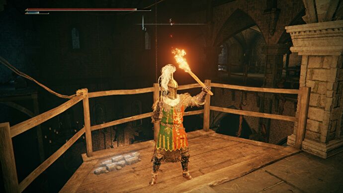 El jugador de Elden Ring sostiene una antorcha en un balcón que da al gran salón del Castillo de Stormveil